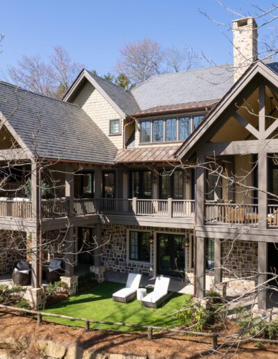A home with a large deck in the woods.