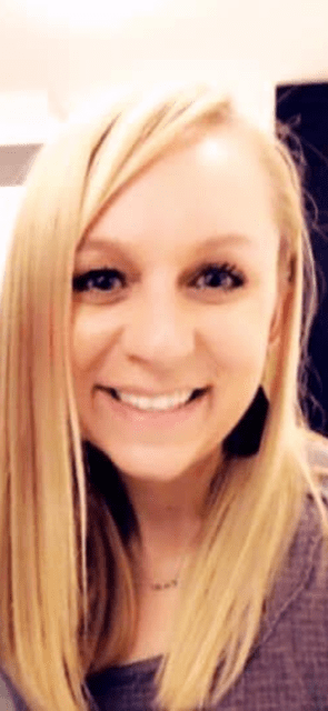 A woman with long blonde hair is smiling for the camera.